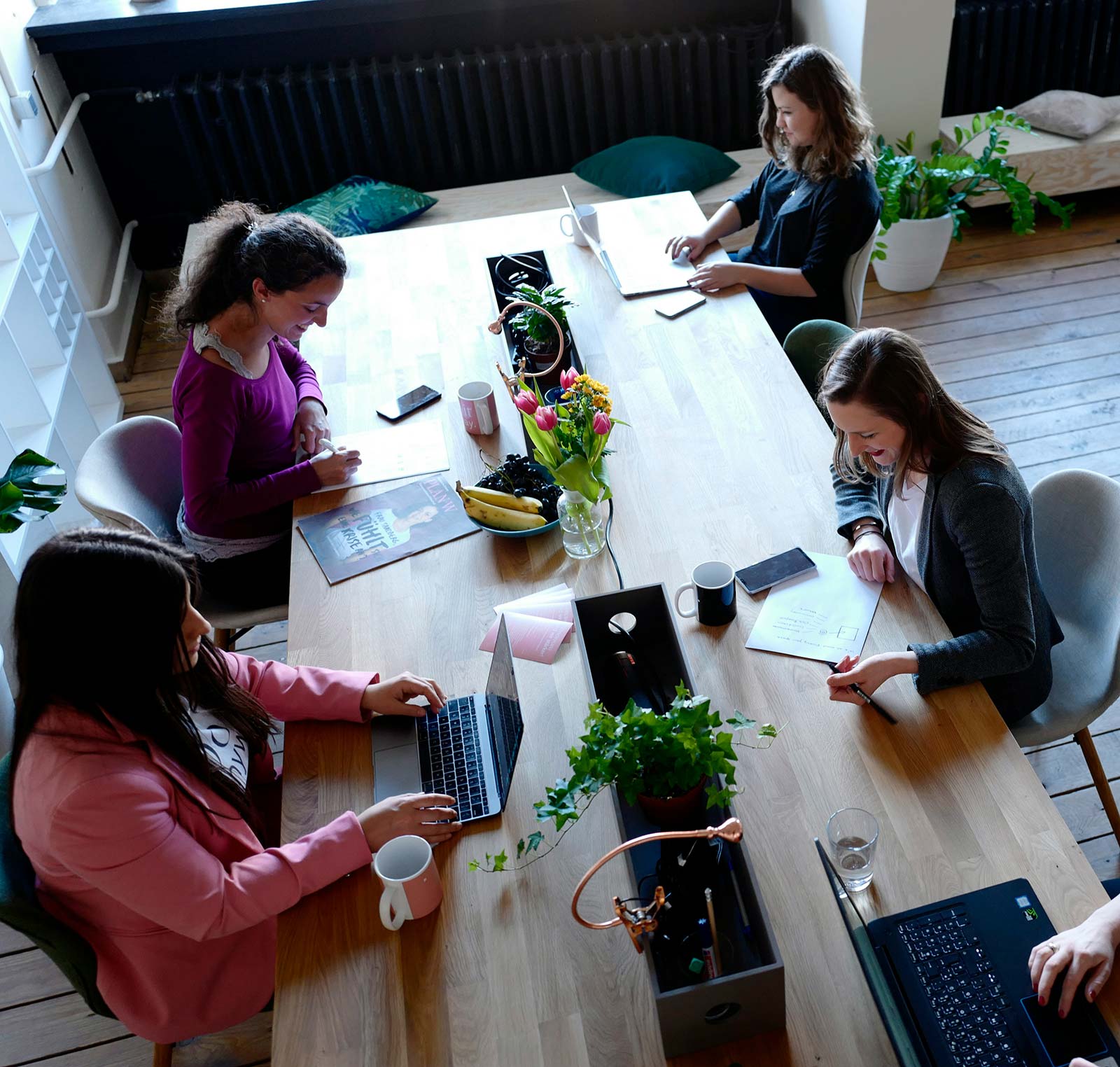 A small team collaborating with laptops in a bright open office